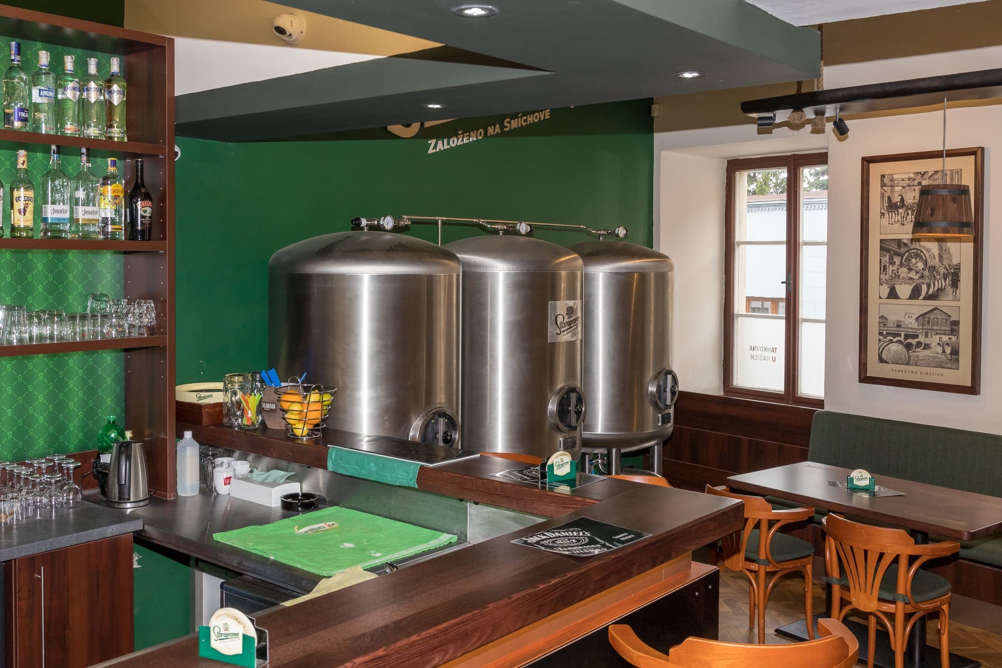 Bar s nerezovými tanky Staropramen, lahvemi a posezením
